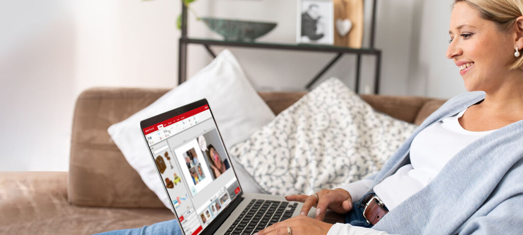 Eine Person am Laptop arbeitet an einer kreativen Gestaltung für ein CEWE Fotobuch.