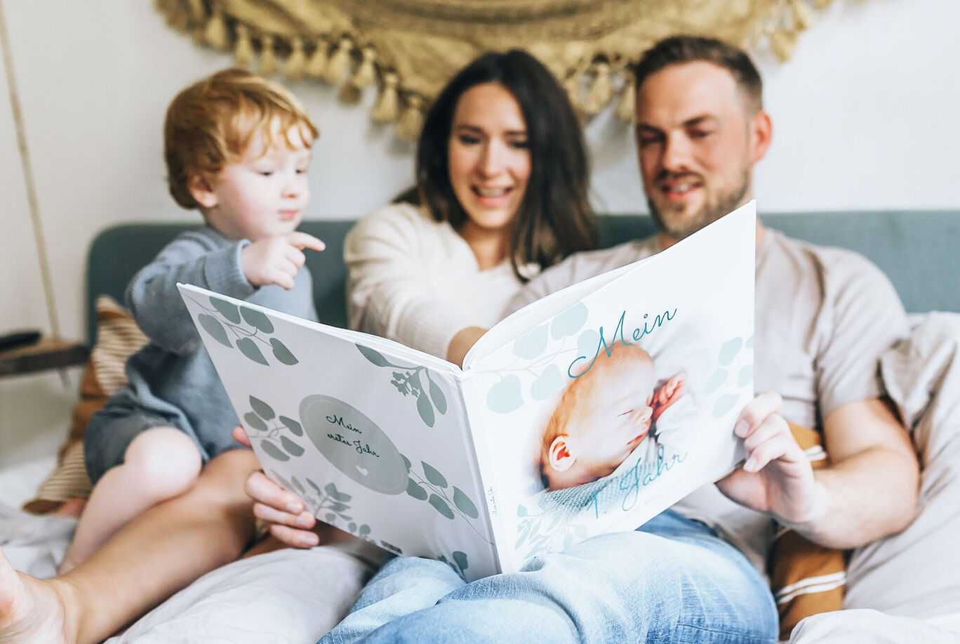 Eine Familie betrachtet ein liebevoll gestaltetes Fotobuch. Es zeigt schöne Erinnerungen, die sie miteinander teilen.