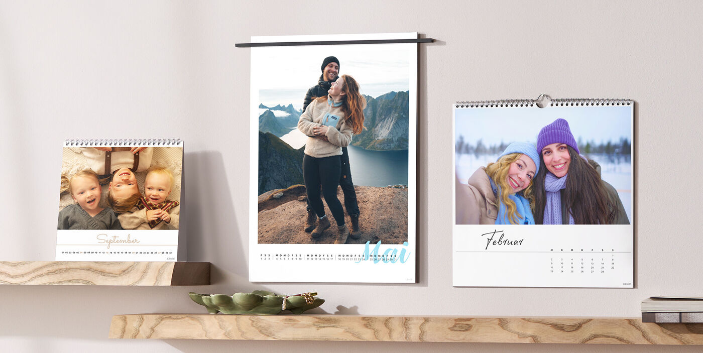 Herzensmomente im Blick: drei persönliche Fotokalender auf Holzablagen – jeden Monat ein Lächeln an der Wand.
