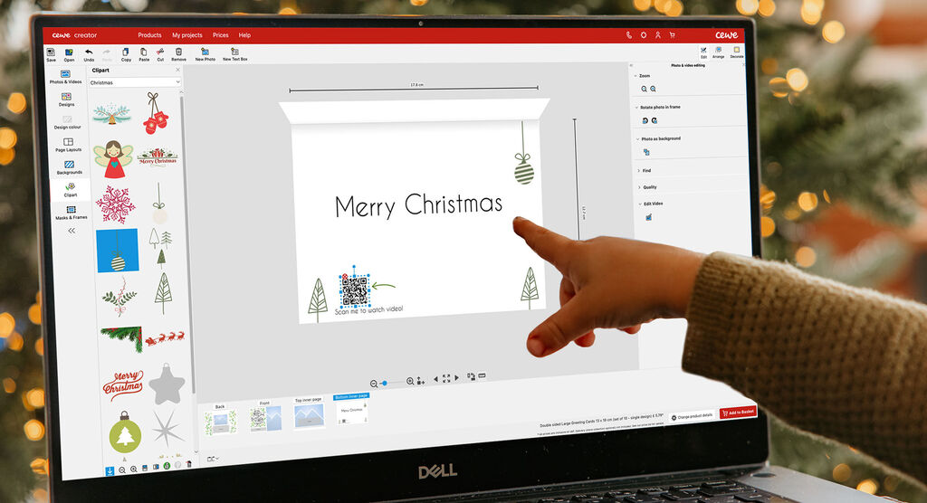 Jemand gestaltet eine digitale Weihnachtskarte. Es sind Elemente wie Weihnachtsbaum und Glanzlichter zu sehen.