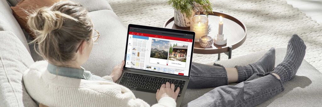 Frau arbeitet an einem Laptop auf einem gemütlichen Sofa in einem hellen Raum