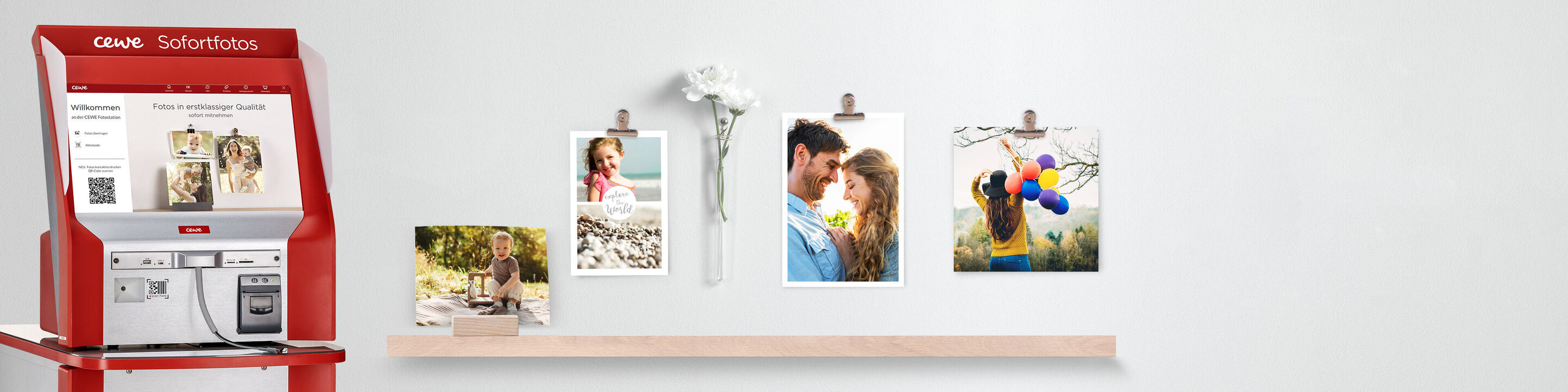 CEWE Fotostation mit Bildern, Blumen und einem kleinen Fotobuch