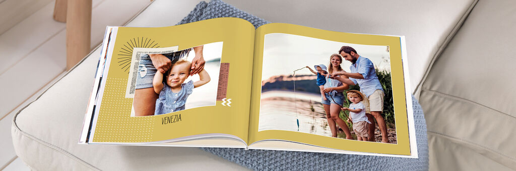 Eine Familie genießt einen sonnigen Tag am Wasser mit einem Fotobuch, das liebevolle Erinnerungen zeigt