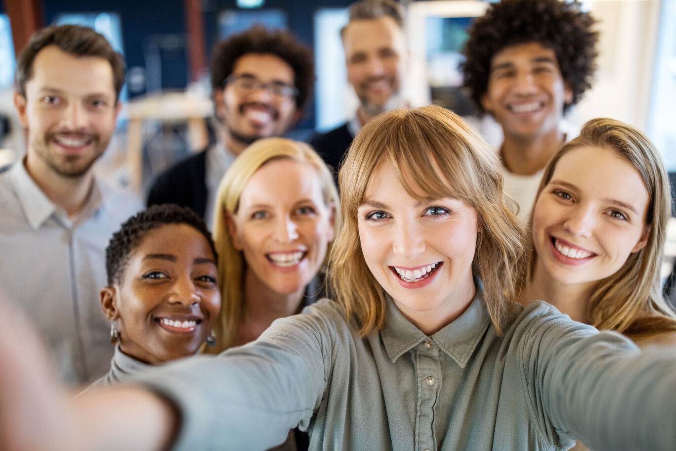 Gruppe von Menschen, die lächeln und ein Selfie machen. Sie stehen alle nah beieinander und zeigen viel Freude. Ein fröhlicher Moment, perfekt für persönliche Erinnerungen.