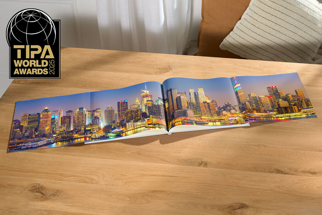 Ein CEWE Fotobuch mit beeindruckendem Stadtpanorama aufgeschlagen auf einem Tisch
