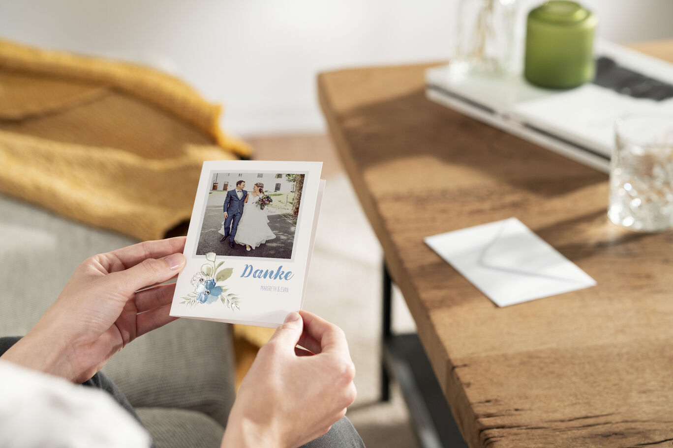 Eine Person hält eine schöne Dankeskarte mit einem Foto eines Paares und einem Blumenmuster in der Hand