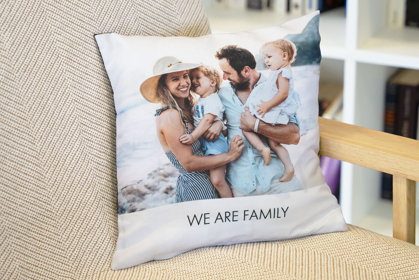 Eine liebevolle Familie posiert auf einem Kissen. Sie genießen einen gemeinsamen Moment am Strand und umarmen sich herzlich.