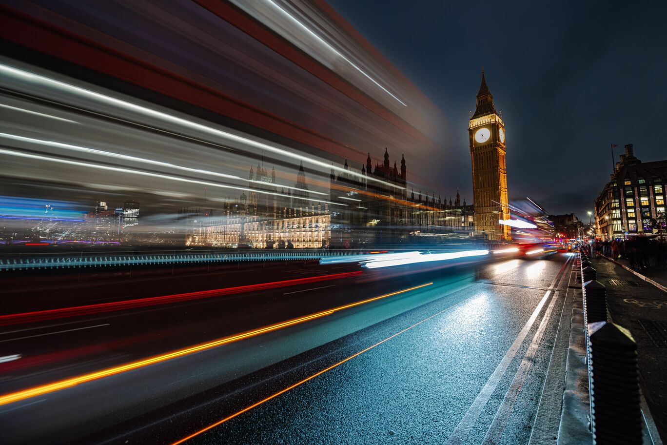 Großartiger Blick auf den Big Ben bei Nacht mit fließendem Verkehr.