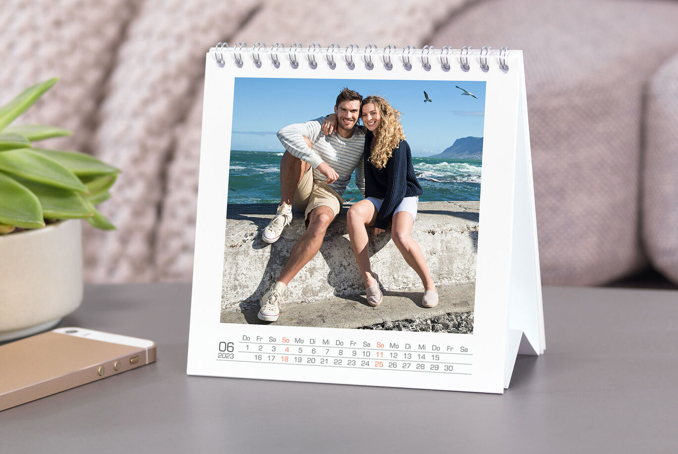 Zwei fröhliche Personen posieren am Strand in einem Fotokalender