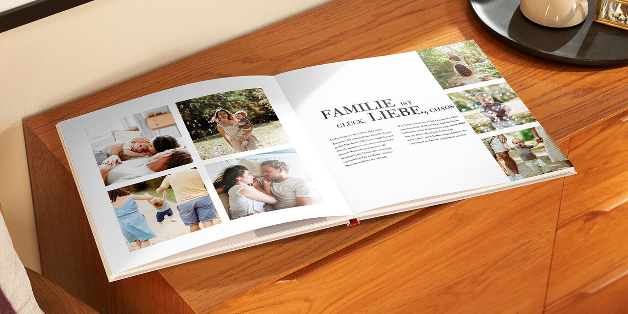 Ein offenes Fotobuch liegt auf einem Holztisch, mit liebevollen Familienfotos.