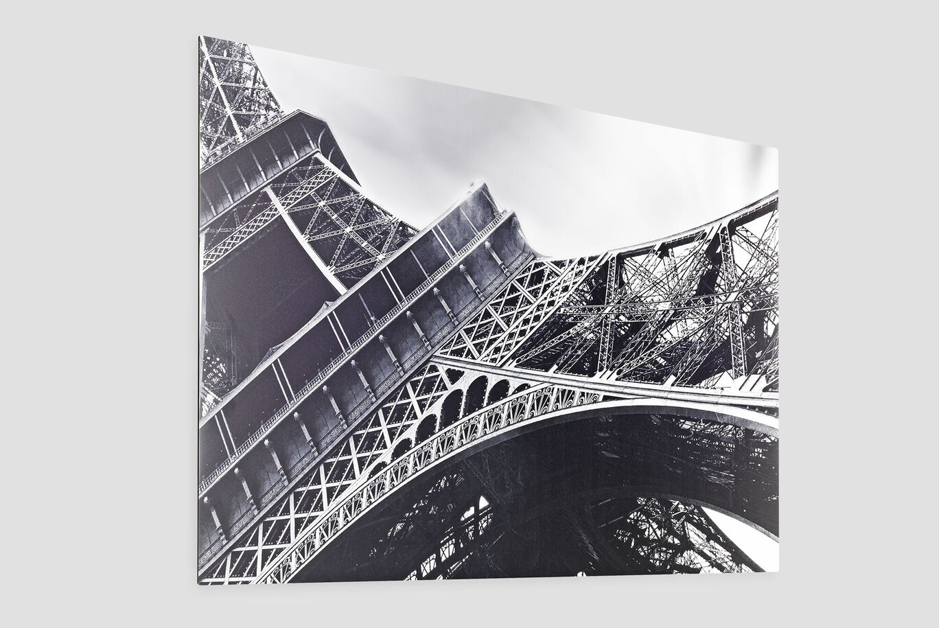 Ein Blick auf den Eiffelturm in Paris. Das Bild zeigt die markanten, eisernen Strukturen des Turms in einem künstlerischen Schwarz-Weiß-Look.
