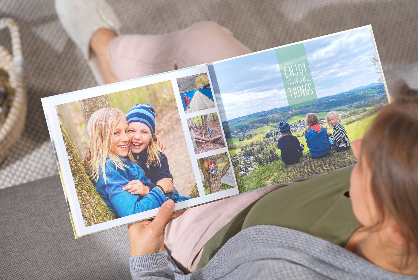 Eine Person blättert in einem CEWE Fotobuch über Urlaubsaktivitäten mit Freunden.