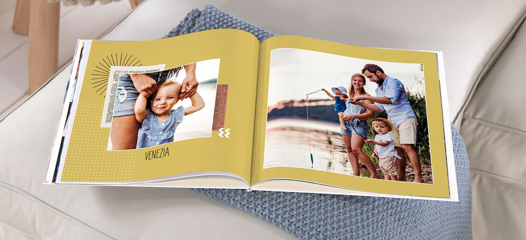 Familie blättert in einem CEWE FOTOBUCH mit einer Urlaubsaufnahme.