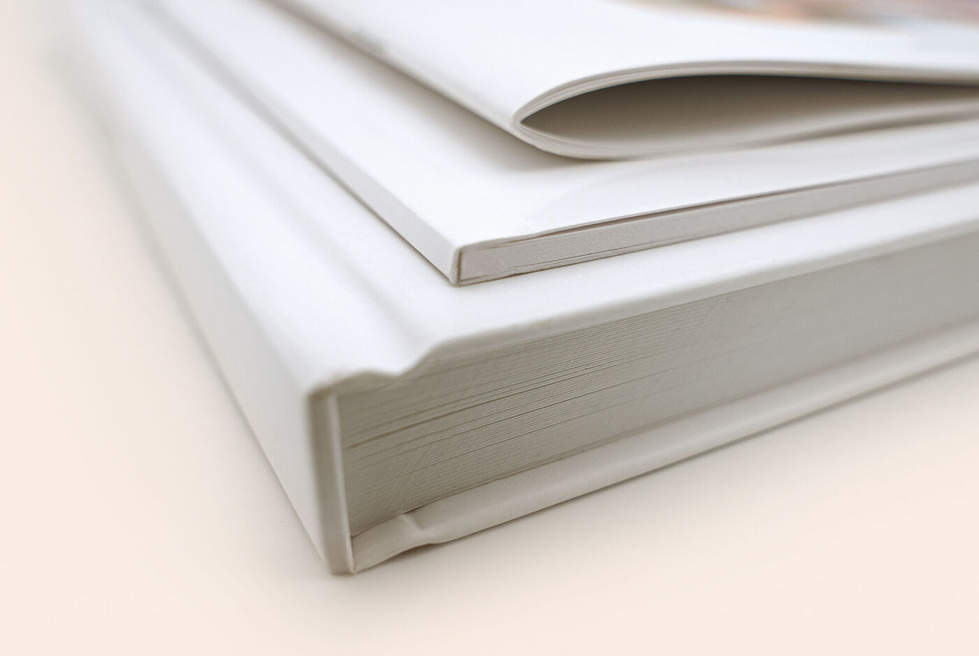 Nahaufnahme aller Einbänden für das CEWE FOTOBUCH aufeinanderliegend. Von oben nach unten: Heft, Softcover und Hardcover.