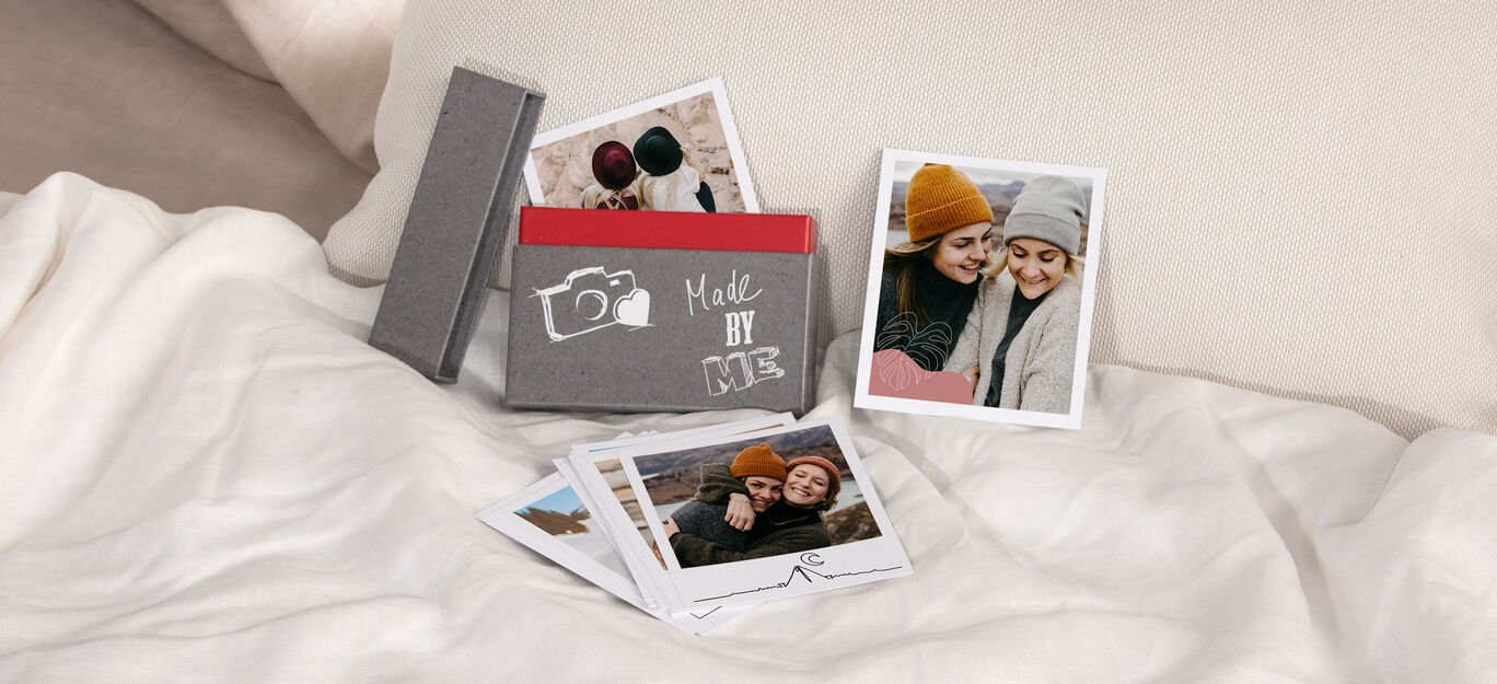 Eine kreative Fotoproduktion mit schönen Erinnerungsstücken und liebevollen Fotos auf einem gemütlichen Bett. Die Fotos zeigen glückliche Momente, die geteilt werden.