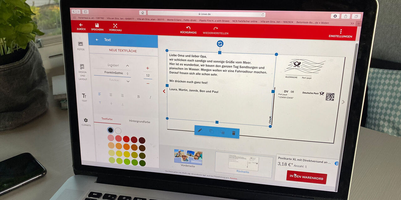 Screenshot des Designs eines CEWE Grußkarten-Editors auf einem Laptop-Display, mit verschiedenen Gestaltungselementen und einer Textbox