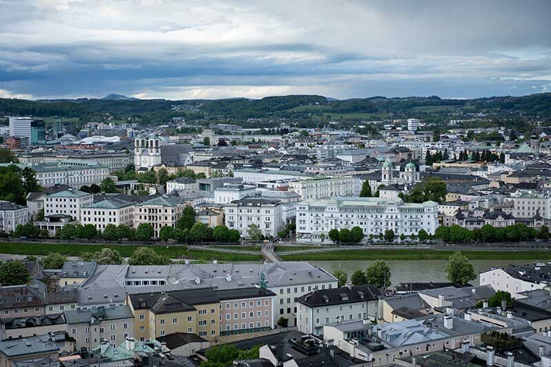 Blick über die schöne Altstadt von Salzburg mit historischen Gebäuden und grünen Hügeln im Hintergrund