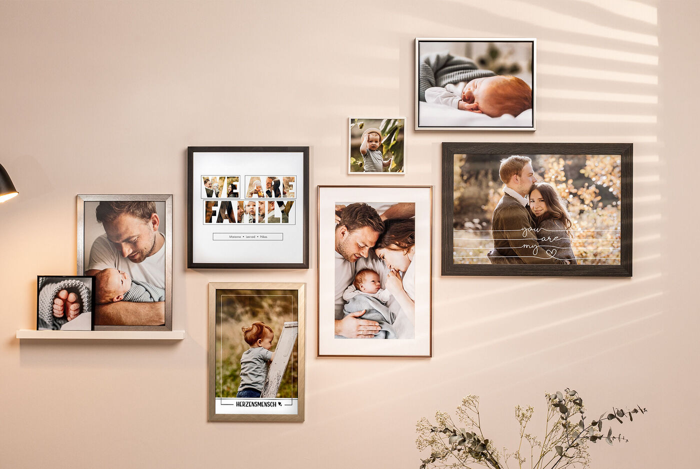 Eine stilvolle Wand mit verschiedenen Familienfotos in Bilderrahmen, die Liebe und besondere Momente zeigen