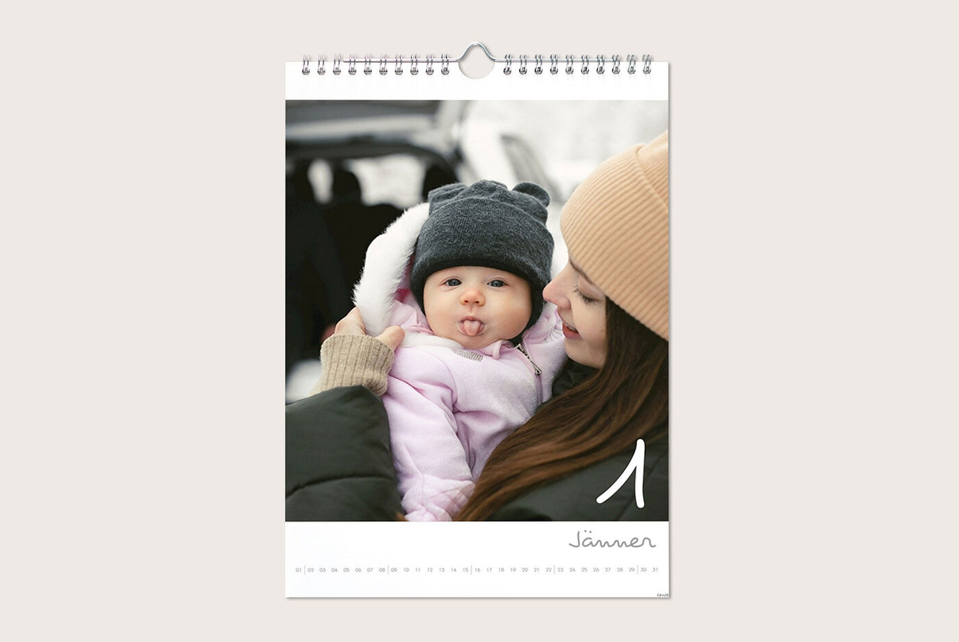 Eine Mutter hält ihr Kind im Januar in einem Fotokalender. Beide tragen warme Kleidung.