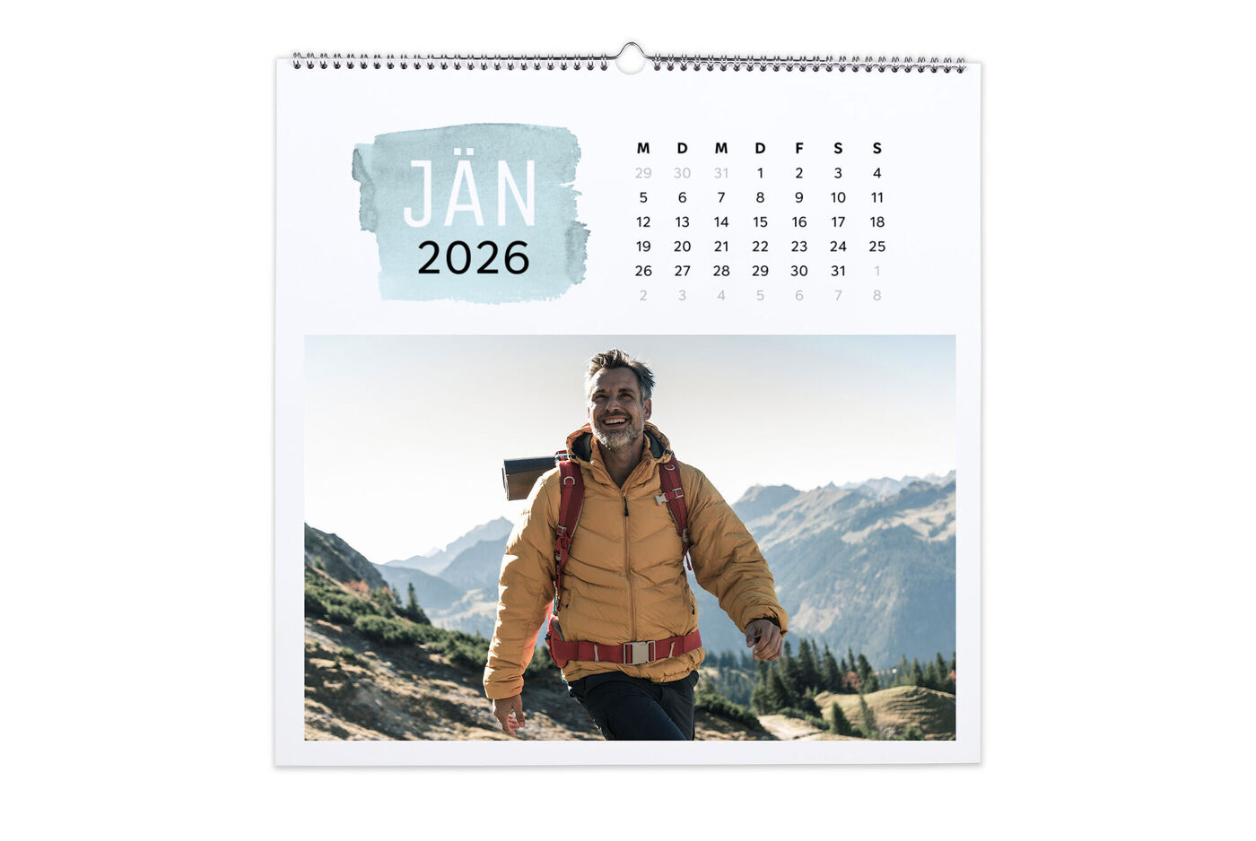 Ein Wanderer in einem warmen Mantel genießt die Natur und die Berge im Hintergrund im Jänner.