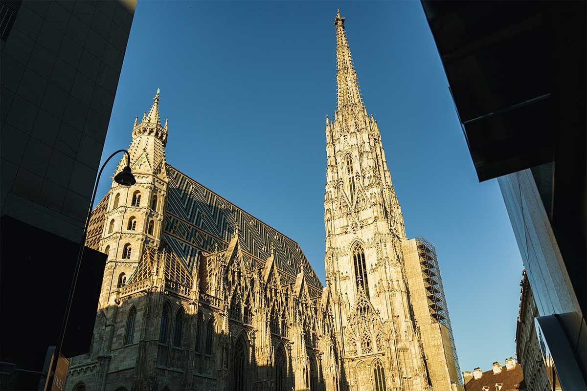 Der Stephansdom in Wien strahlt im warmen Licht der Abendsonne und ist von moderner Architektur umgeben