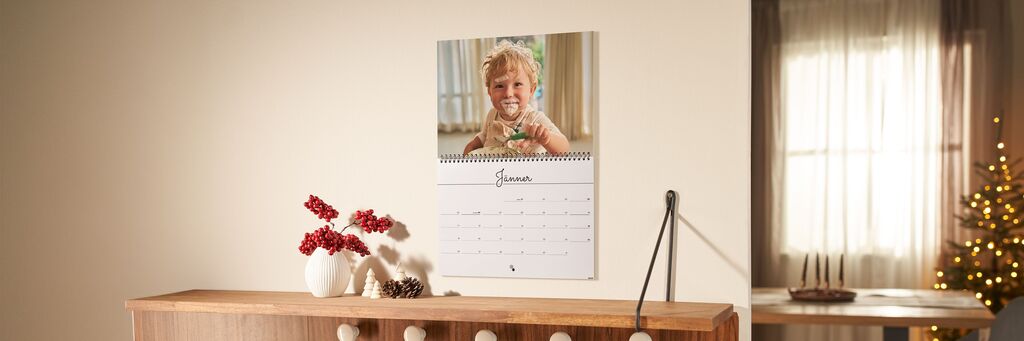 Ein Fotokalender mit den Feiertagen im Jänner in einer festlich geschmückten Wohnung und einem Foto eines Kindes.