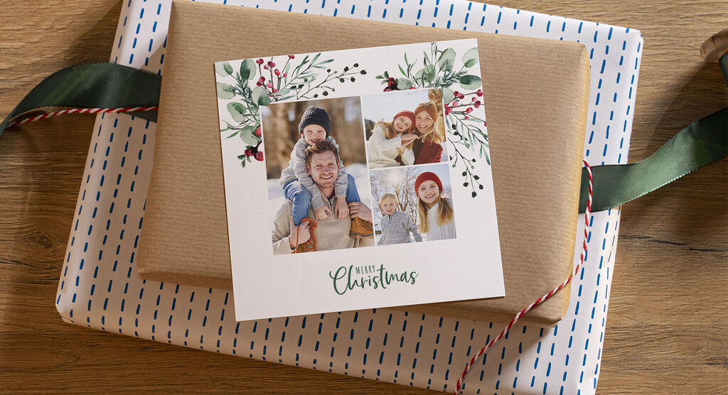 Ein hübsch verpacktes Geschenk mit einem Foto von einer Familie und Weihnachtsmotiven auf der Karte
