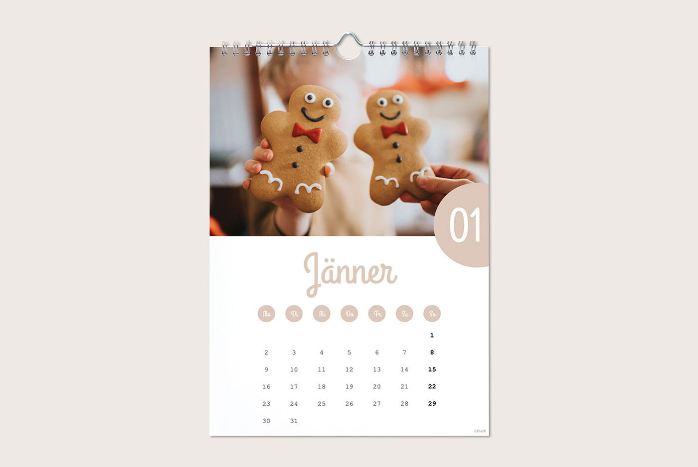 Zwei Menschen halten Lebkuchenkekse in Form von Männern, umgeben von einem Kalender mit dem Monat Januar.