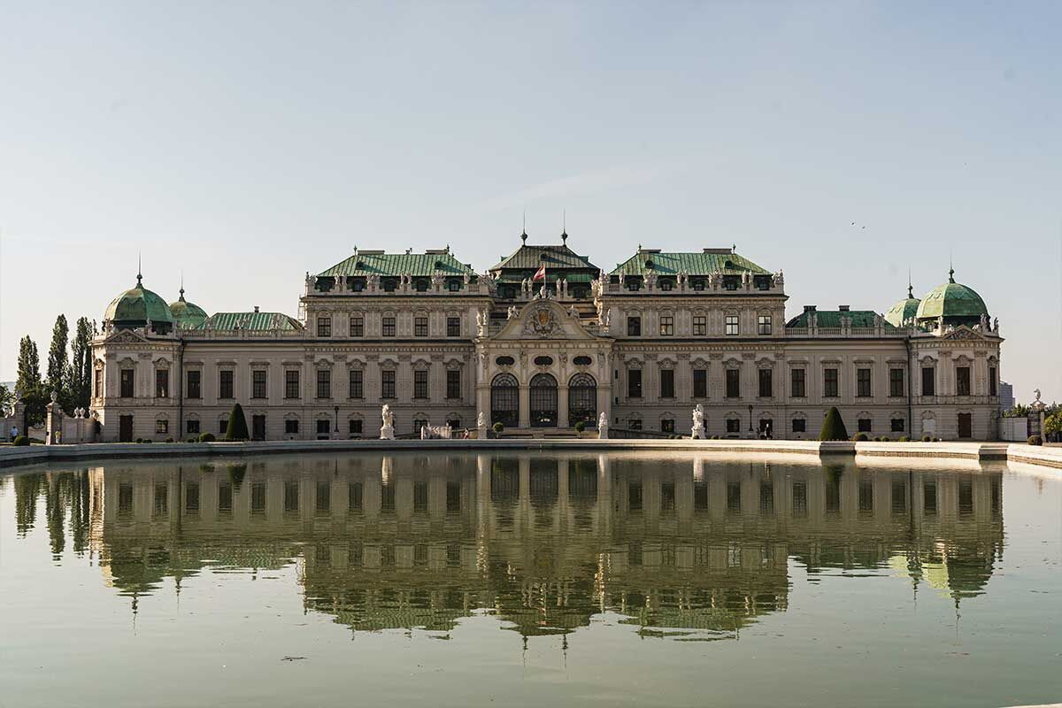 Das prachtvolle Schloss Belvedere in Wien spiegelt sich im ruhigen Wasser des Teichs.