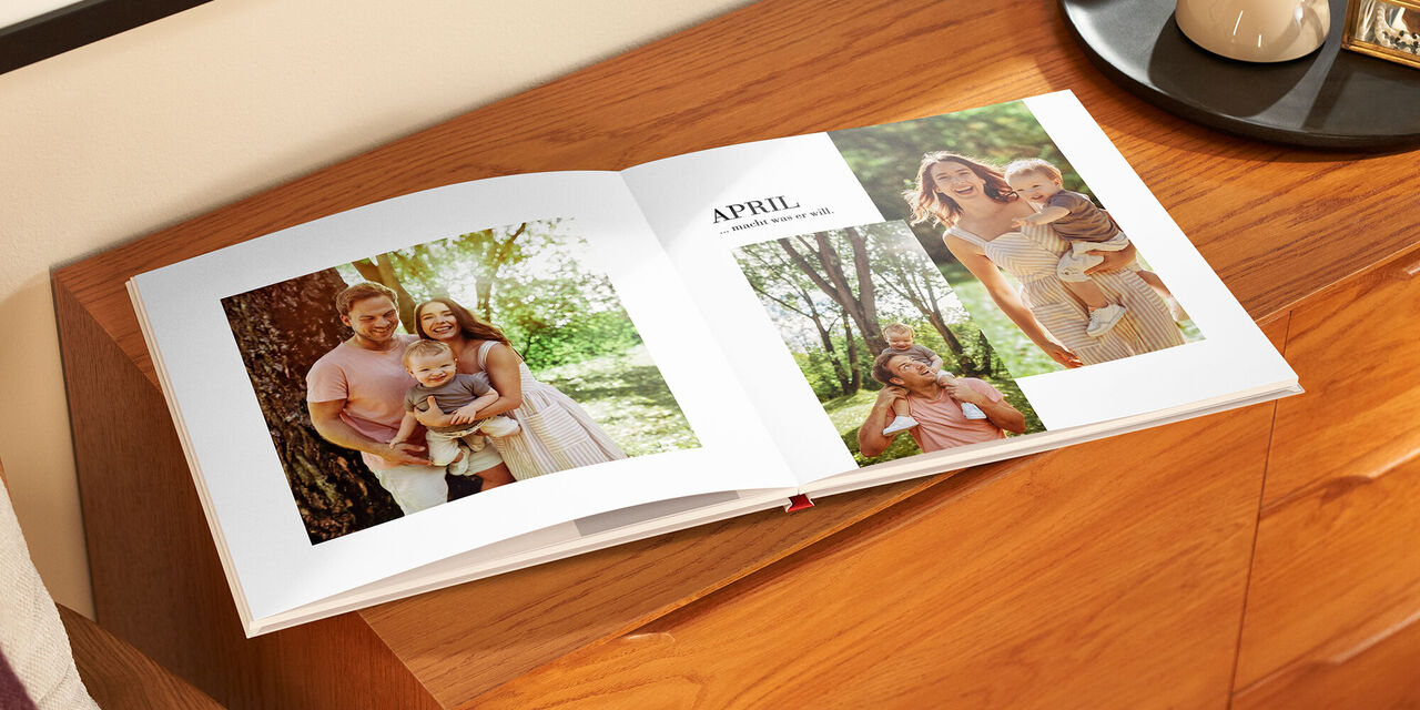 Ein offenes Fotobuch zeigt Familienmomente im Monat April.