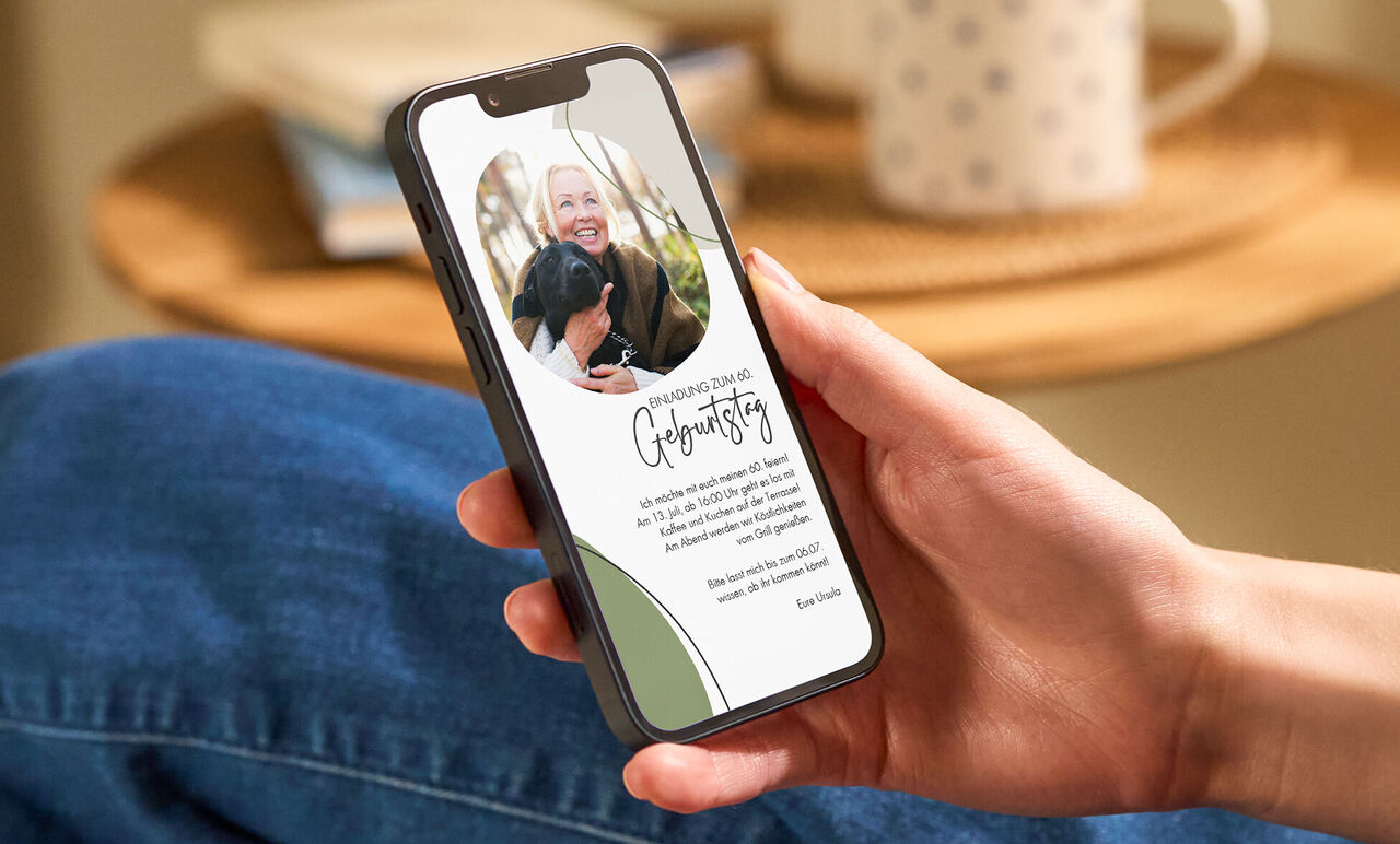 Person hält Smartphone in der Hand mit geöffneter CEWE Grußkarte und Foto