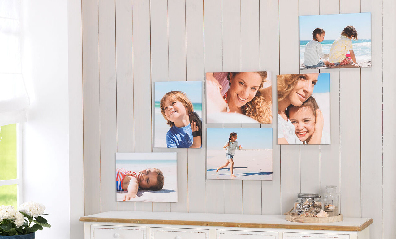 Bunte Wandbilder von Familienmomenten am Strand, mit fröhlichen Kindern und Erwachsenen.