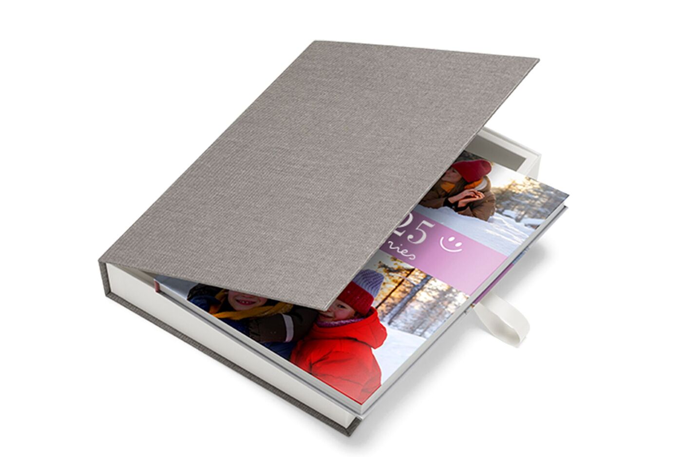 Eine offene Geschenkbox mit einem bunten CEWE FOTOBUCH darin.
