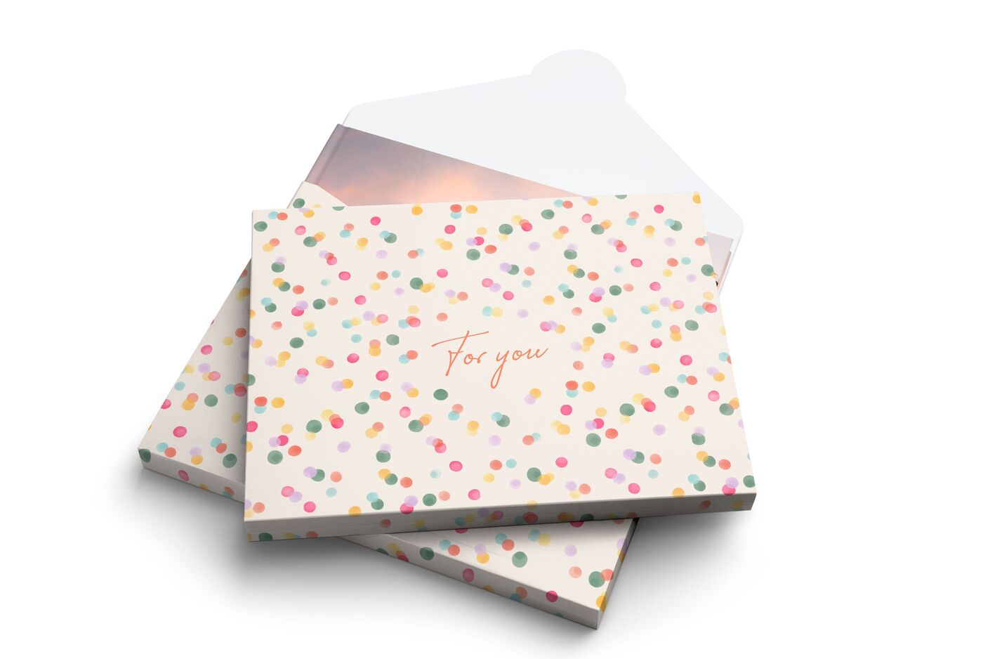 Die Geschenkverpackung für das CEWE FOTOBUCH mit einem beigen Cover, dekoriert mit bunten Punkten und der Aufschrift „For you".