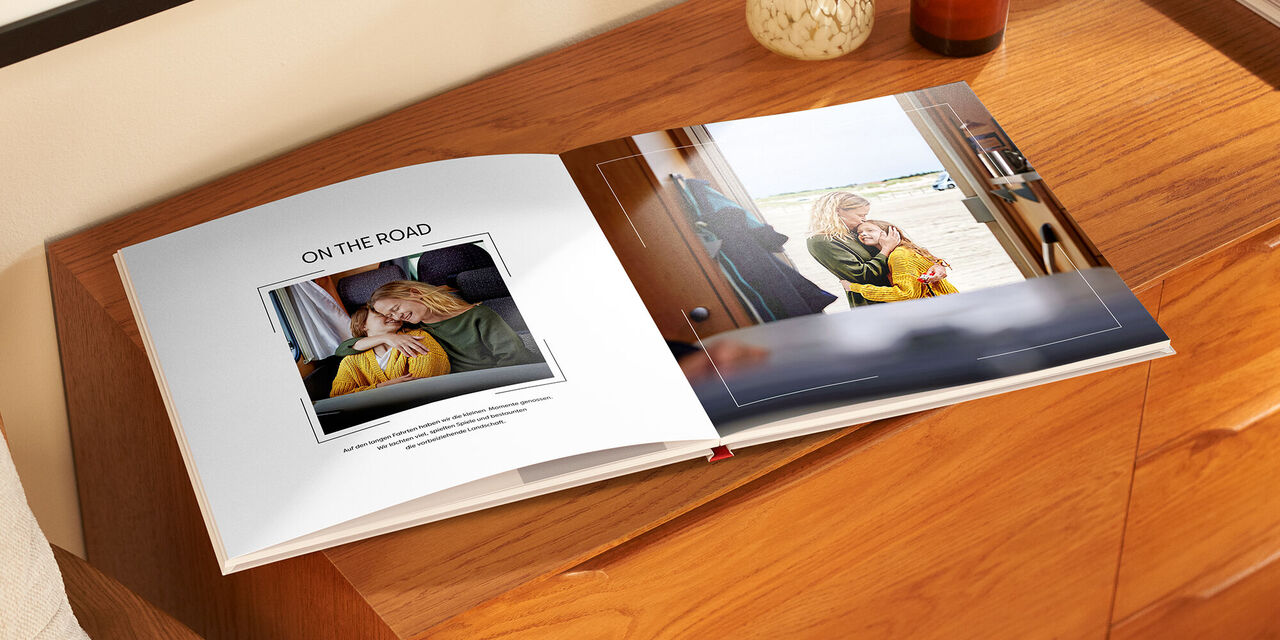 Geöffnetes CEWE FOTOBUCH mit Fotos und Text, liebevolle Momente festgehalten