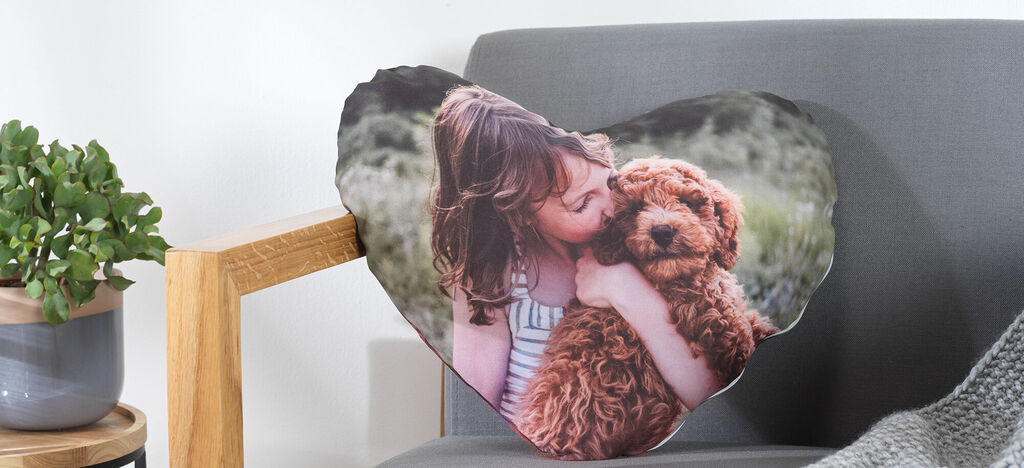 Herzkissen mit einem Mädchen, das einen Hund liebkost