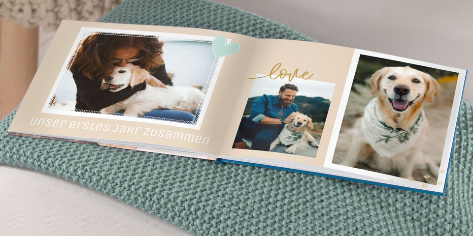 Ein liebevolles Fotobuch auf einer Decke mit Bildern von Freunden und einem Hund.