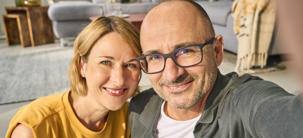 Ein glückliches Paar macht ein Selfie in einem gemütlichen Wohnraum mit modernen Möbeln