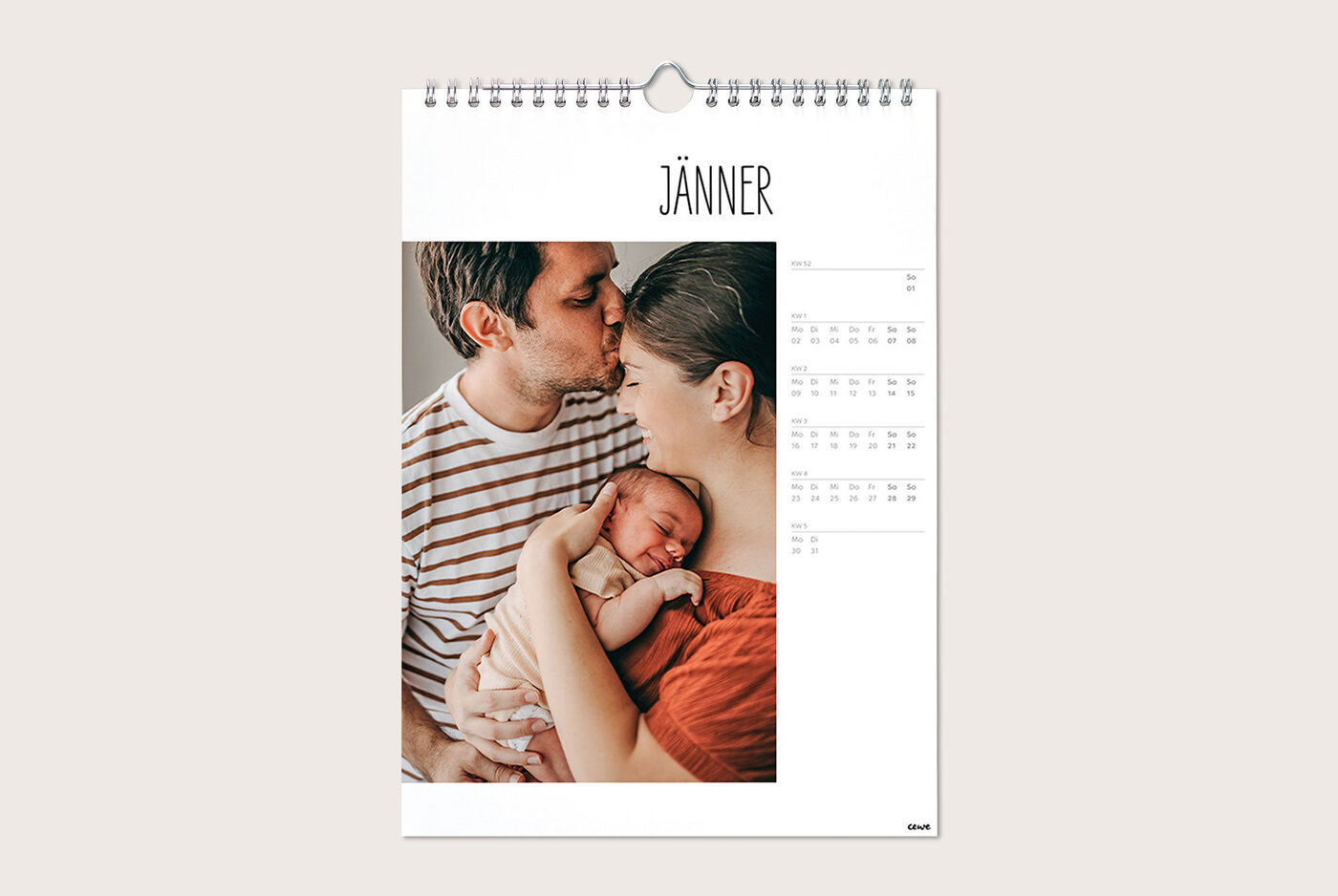 Ein Paar hält gemeinsam ein Baby in einem Monatskalender.