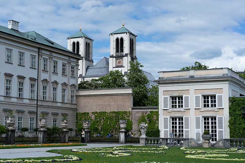 Ansicht eines schönen Gartens mit Gebäude und Kirchtürmen im Hintergrund