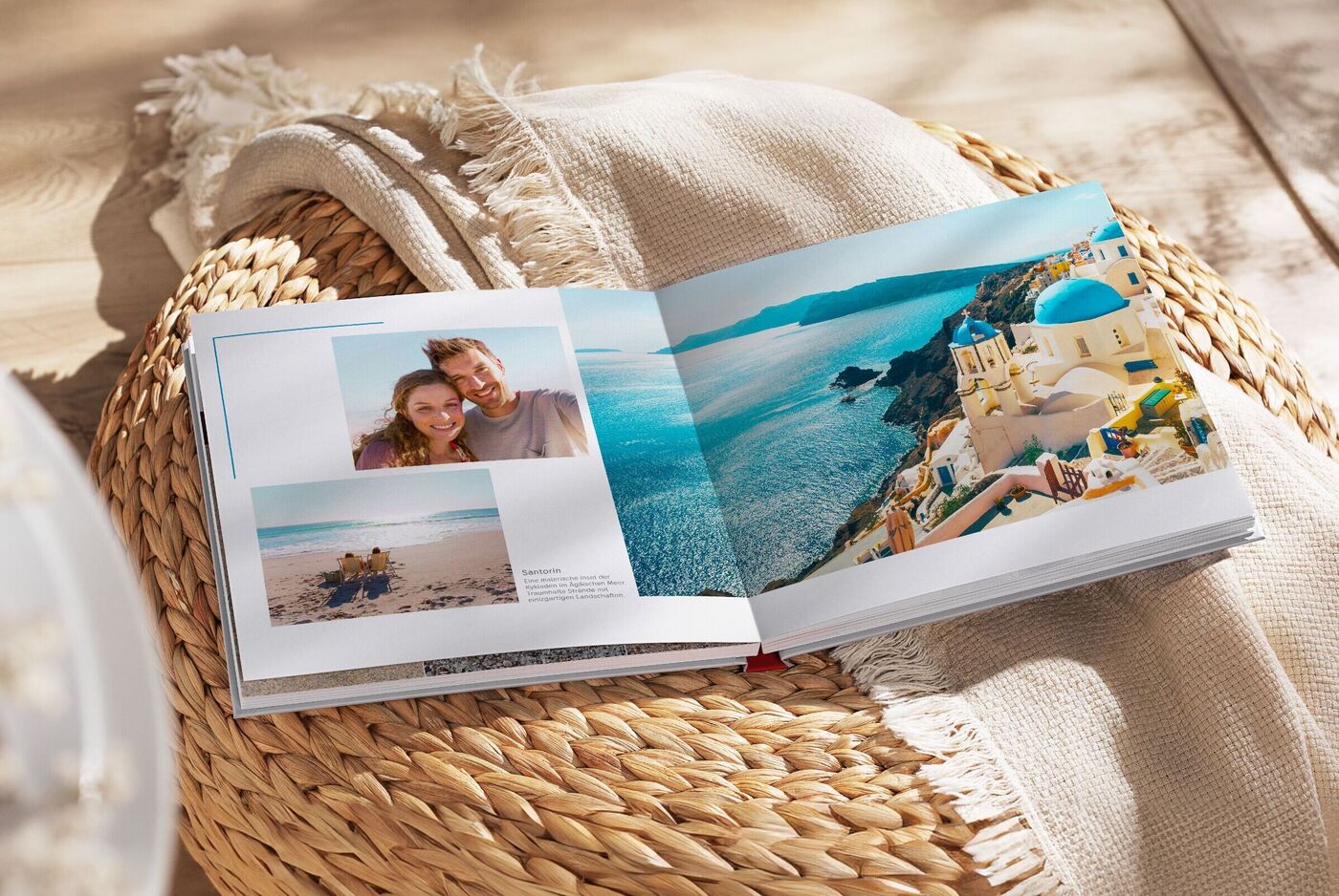 Ein geöffnetes CEWE FOTOBUCH mit Urlaubserinnerungen und Fotos am Meer.