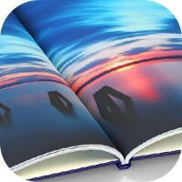 Nahaufnahme eines offenen CEWE FOTOBUCH mit einer Landschaftsaufnahme im Sonnenuntergang mit einer klassischen Buchbindung mit Mittelfalz