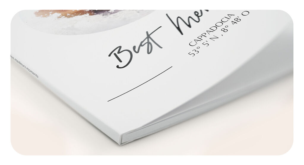 Detailansicht eines CEWE FOTOBUCHs mit Softcover, das leicht aufgeschlagen ist.