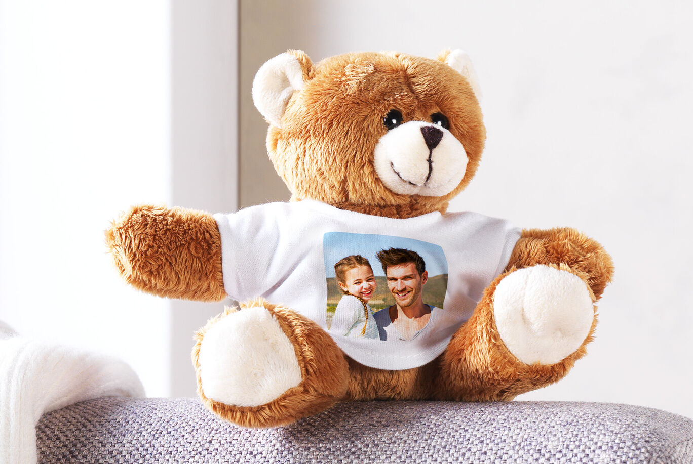 Kuscheliger Teddybär mit bedrucktem T-Shirt. Auf dem Shirt ist ein Foto abgebildet.