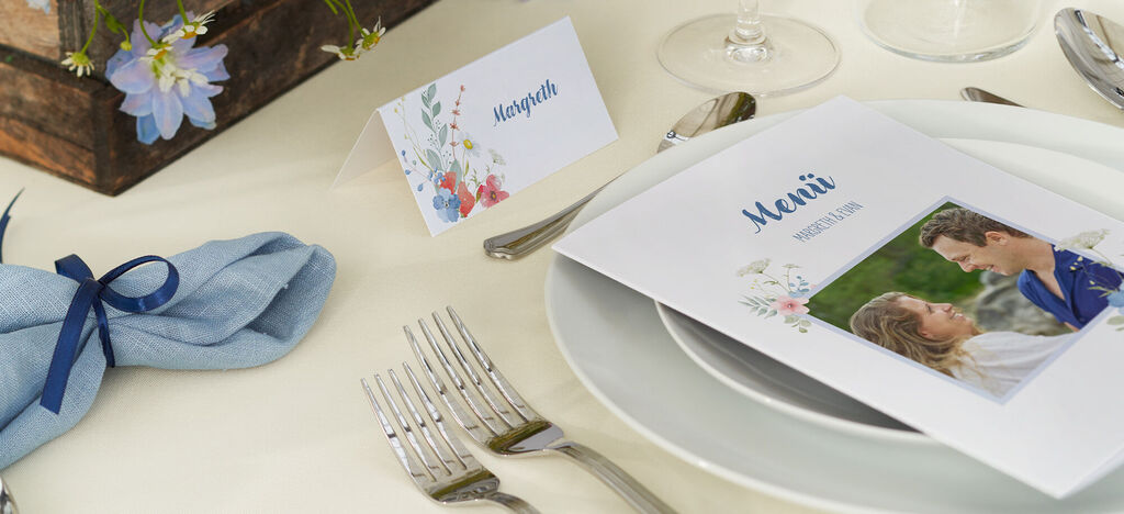 Festlich gedeckter Tisch mit Menükarte und Blumenarrangement