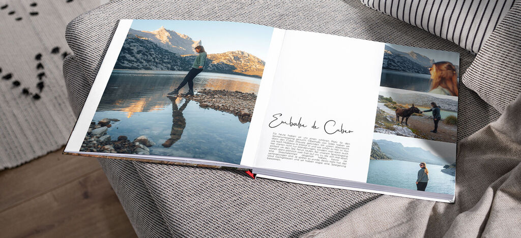 Ein offenes CEWE FOTOBUCH zeigt eine Person, die am Wasser steht. Sie blickt auf die Berge, ihr Schatten spiegelt sich im Wasser. Rundherum sind Fotos von verschiedenen Erlebnissen im Buch.