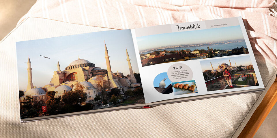 Im geöffneten CEWE Fotobuch sind beeindruckende Fotos von Istanbul zu sehen, darunter die Hagia Sophia und eine schöne Küstenansicht, die Erinnerungen an den Urlaub wecken.