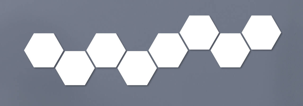 Sechs farbige hexagonale Formen in einer Linie auf grauem Hintergrund