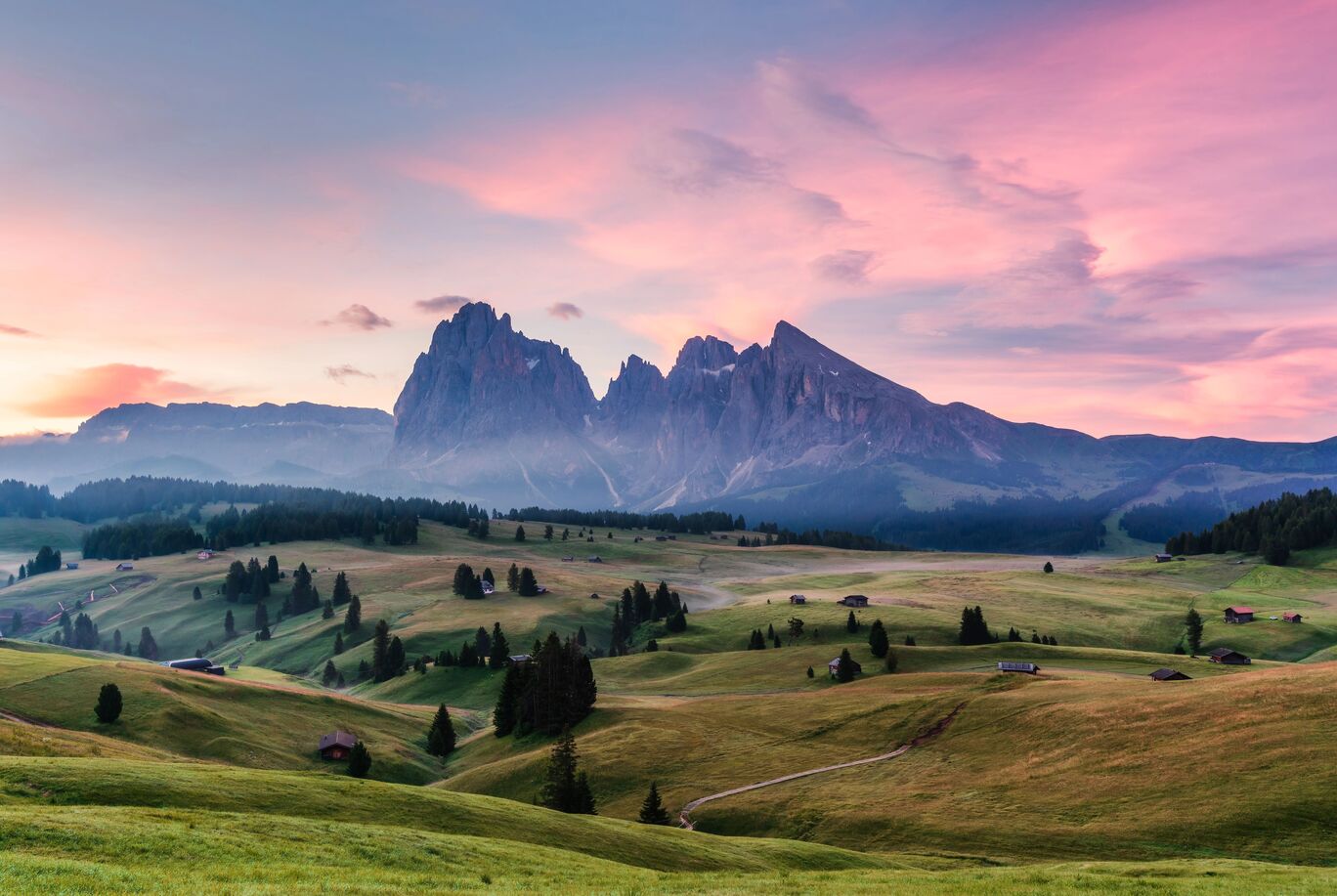 Blick auf majestätische Berge und sanfte Wiesen bei Sonnenaufgang in Südtirol