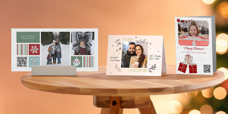 Drei wunderschön gestaltete CEWE Grußkarten auf einem Tisch, passend zur Weihnachtszeit, in verschiedenen Designs